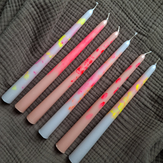 Handgemachte Dip-Dye Stabkerzen in Pastell- und Neonfarben auf braunem Stoff – moderne bunte Kerzen für Dekoration und Tischdeko