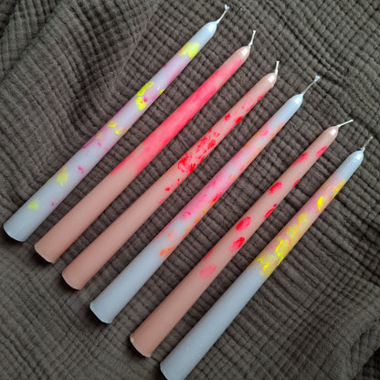 Handgemachte Dip-Dye Stabkerzen in Pastell- und Neonfarben auf braunem Stoff – moderne bunte Kerzen für Dekoration und Tischdeko